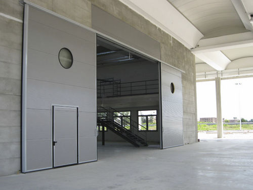 Porte industrielle sectionnelle - ALLMURA - MURA - coulissante / en métal / pour établissement public