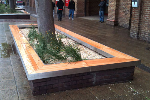 Banc public contemporain - HOWARD CENTRE, BEDFORD - Factory Street Furniture - en bois / en inox / avec jardinière intégrée