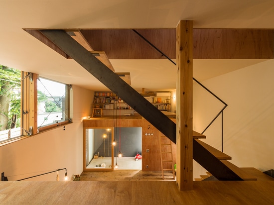 La maison en bois compacte par des architectes de Takeru Shoji se tient à côté des arbres de 200 ans