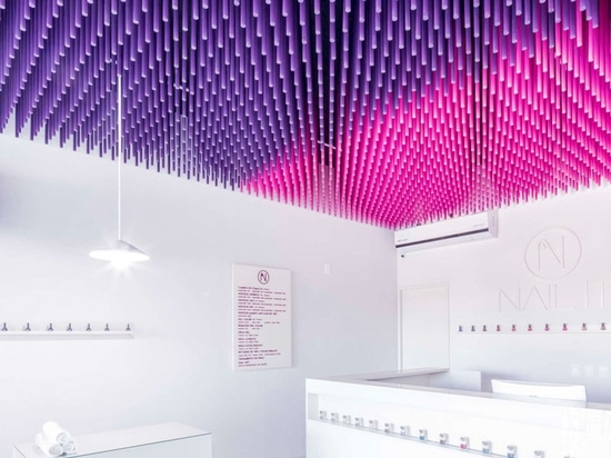 Les bâtons colorés pendent du plafond de ce salon d'ongle