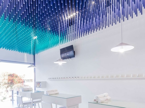 Les bâtons colorés pendent du plafond de ce salon d'ongle