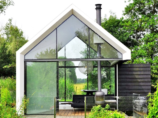 La cabine minuscule en verre et de bois de construction se plie abilement ouvert pour se mélanger dedans avec le paysage néerlandais