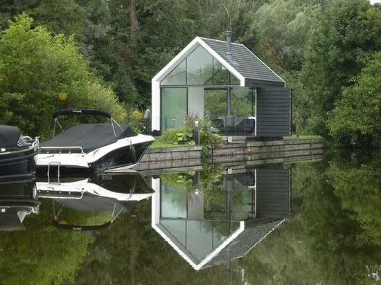 La cabine minuscule en verre et de bois de construction se plie abilement ouvert pour se mélanger dedans avec le paysage néerlandais