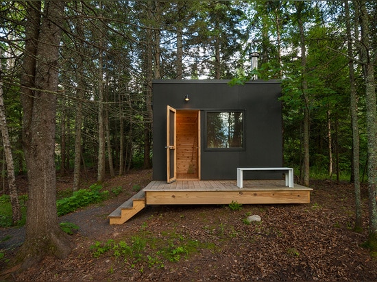 La galerie de bois de construction se repose au-dessus de la véranda de la retraite du bord de lac de l'architecte de Salmela