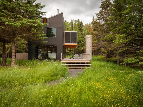 La galerie de bois de construction se repose au-dessus de la véranda de la retraite du bord de lac de l'architecte de Salmela