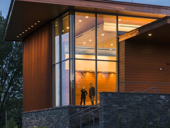 Le bâtiment est plaqué avec le cèdre horizontal et vertical sur une base de fieldstone de granit.