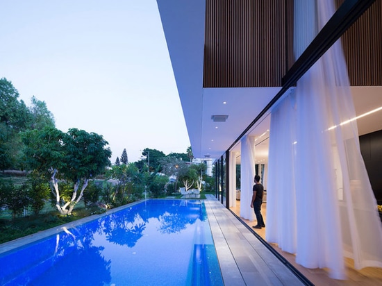 Les grands murs de verre coulissants donnent cette maison facile d'accès à la piscine