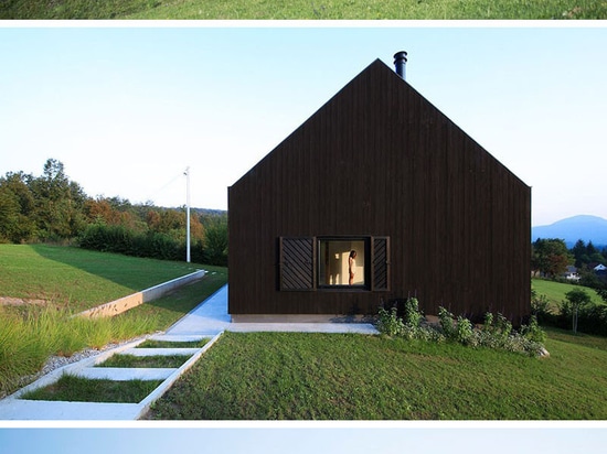 Cette petite maison noire se repose sur une pente dans la campagne croate