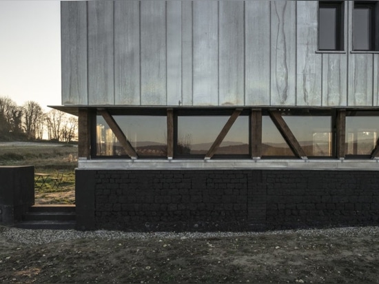 Ruines de grange transformées en maison contemporaine avec la station thermale