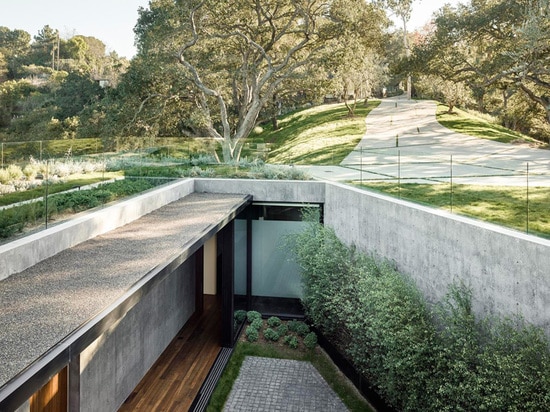 Une maison de verre et de béton avec des vues de gorge