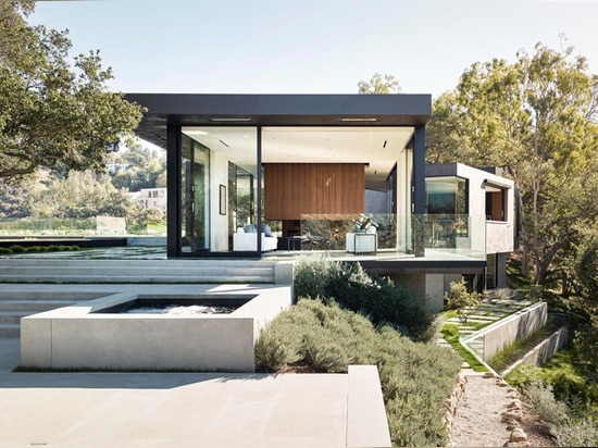 Une maison de verre et de béton avec des vues de gorge