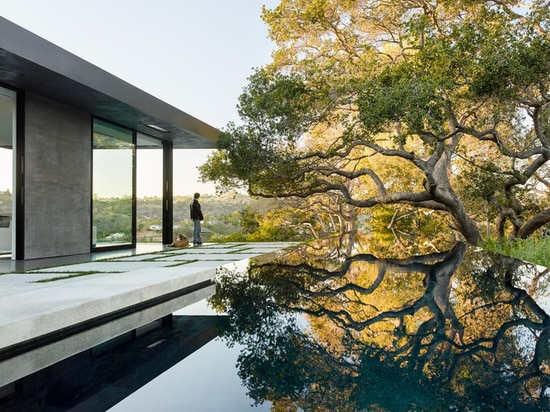 Une maison de verre et de béton avec des vues de gorge