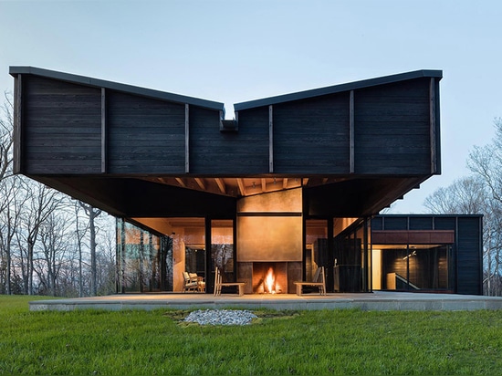 le chia de desai unit trois structures excentrées pour former la maison carbonisée de lac de bois de construction au Michigan