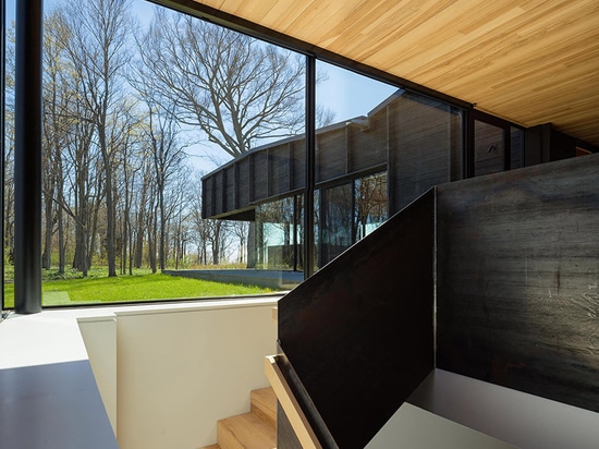 le chia de desai unit trois structures excentrées pour former la maison carbonisée de lac de bois de construction au Michigan