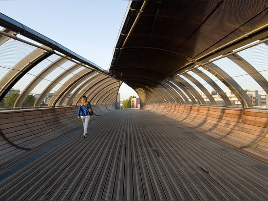 La passerelle de Villetaneuse de passage unfurls comme une feuille au-dessus des voies de train en dehors de Paris