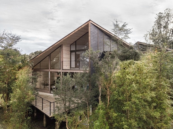 La maison chilienne de lac est coupée en deux volumes habillés de bois de construction