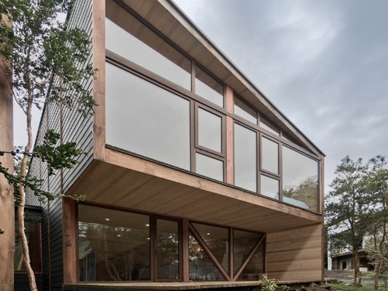 La maison chilienne de lac est coupée en deux volumes habillés de bois de construction