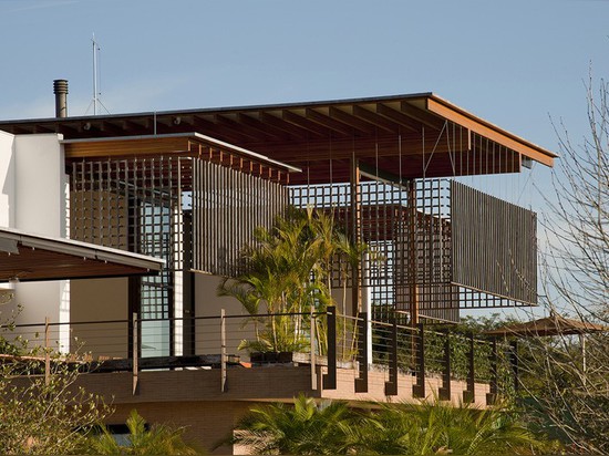 Un trellis en bois filtre le soleil, mais pas les vues de cette maison au Brésil