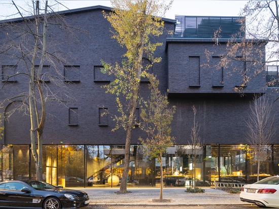 La YTAA transforme une vieille villa en un musée avec des surfaces irrégulières sombres et une base vitrée à Bucarest