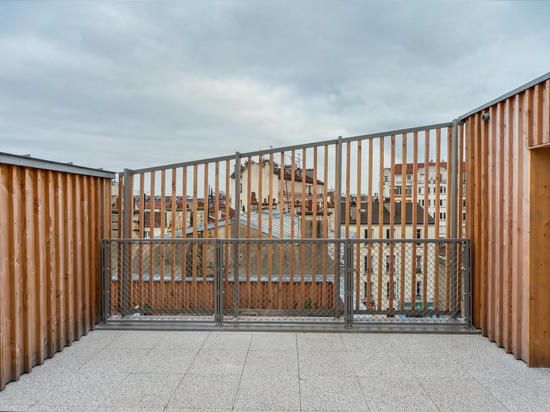 Les façades en bois préfabriquées sont engainées en lamelles non traitées de pin, qui développeront graduellement une patine argentée avec le temps. Lisez plus : Le logement parisien préfabriqué es...