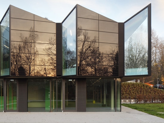 Le bâtiment ? l'enveloppe de s est plaquée dans les fenêtres vitrées r3fléchissantes, qui fournissent l'éclairage normal à l'intérieur, et reflète la forêt verte dehors. Le bois de construction et ...