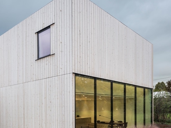 Un bureau à domicile a été rendu possible par la construction d'un bureau le long d'un mur de fenêtres à l'intérieur de cette maison