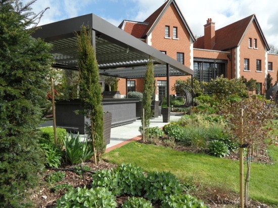 Salon extérieur avec pergola bioclimatique dans une maison de campagne en Angleterre