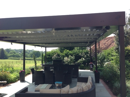 Salon extérieur avec pergola bioclimatique dans une maison de campagne en Angleterre