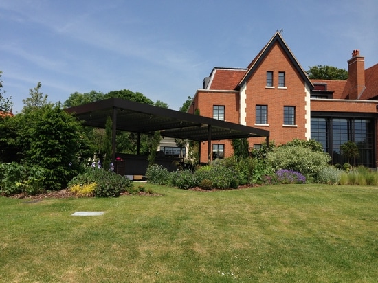 Salon extérieur avec pergola bioclimatique dans une maison de campagne en Angleterre