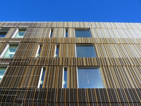 gradient de couleur de la façade visible, du foncé (rez-de-chaussée) au clair (étage supérieur)