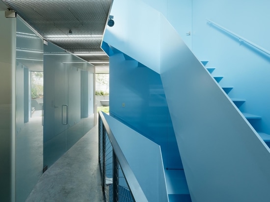 L'extérieur en bois de cette maison cache à l'intérieur un remarquable escalier bleu