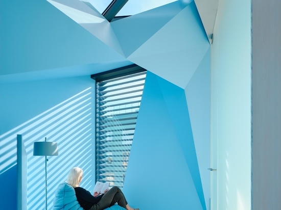 L'extérieur en bois de cette maison cache à l'intérieur un remarquable escalier bleu