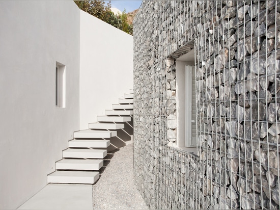 L'architecture A31 enveloppe l'hôtel de relux avec des murs de gabion sur l'île grecque