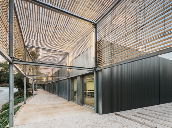 un nouveau passage inclus par des bandes de bois de construction sert de couloir et de terrasse communale