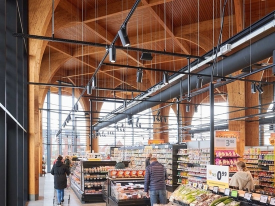 D'élégantes colonnes de bois semblables à des cathédrales soutiennent un auvent au-dessus de ce nouveau supermarché