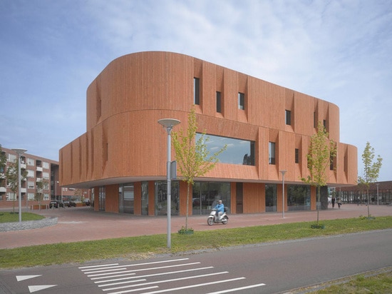 La maçonnerie verticale et les cavités profondes de fenêtre donnent un aspect "BOLD" à ce nouveau bâtiment culturel de centre