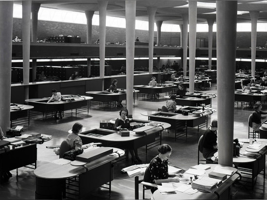 Commis travaillant dans la grande salle de travail du bâtiment d'administration dans les années 40