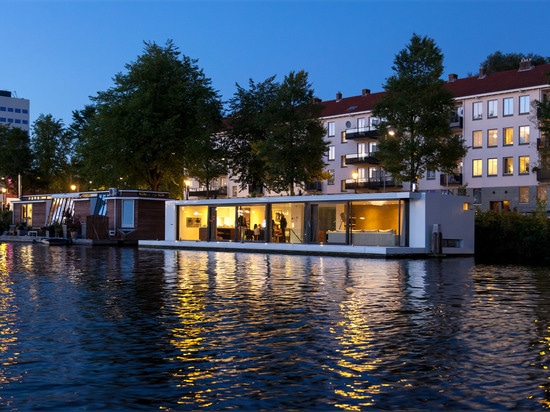 Le flottement à la maison par +31 architectes est amarré sur un fleuve d'Amsterdam