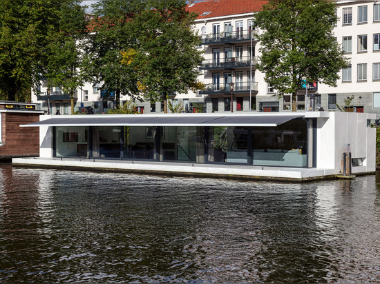 Le flottement à la maison par +31 architectes est amarré sur un fleuve d'Amsterdam