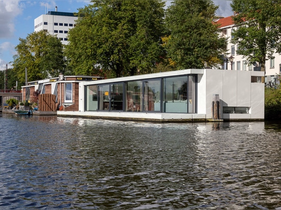 Le flottement à la maison par +31 architectes est amarré sur un fleuve d'Amsterdam