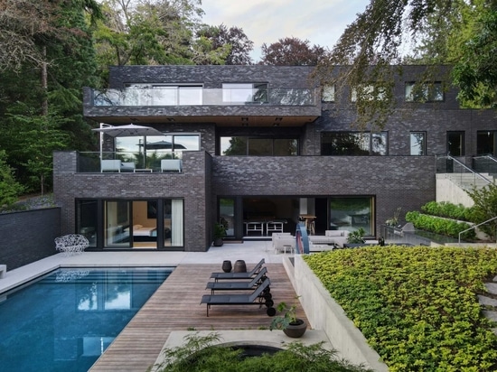 Un extérieur en briques sombres pour une maison entourée d'arbres