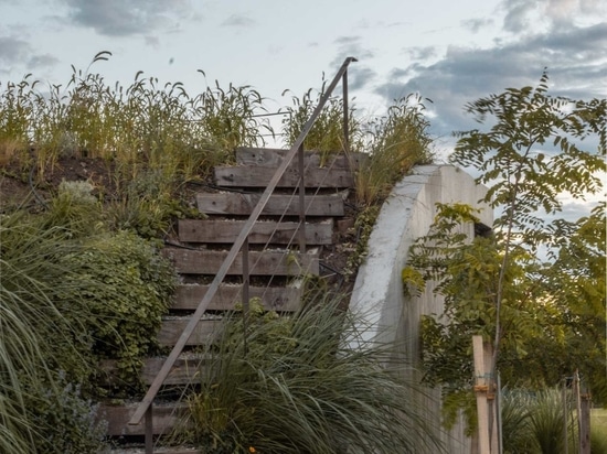 Une maison qui s'élève du sol et forme un jardin à trois niveaux