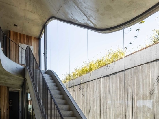 Une maison qui s'élève du sol et forme un jardin à trois niveaux