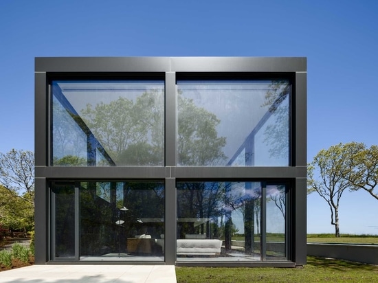 Une grille de grandes fenêtres maximise la vue sur l'eau dans cette maison moderne