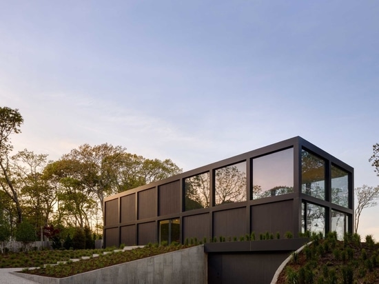 Une grille de grandes fenêtres maximise la vue sur l'eau dans cette maison moderne