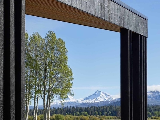 L'intérieur en bois chaleureux contraste avec l'extérieur en cèdre noir carbonisé de ce Ranch Lodge dans l'Oregon