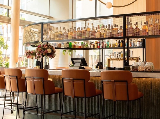 Bar industriel-chic avec des textures en treillis métallique et des sièges contemporains chez Ace Porter
