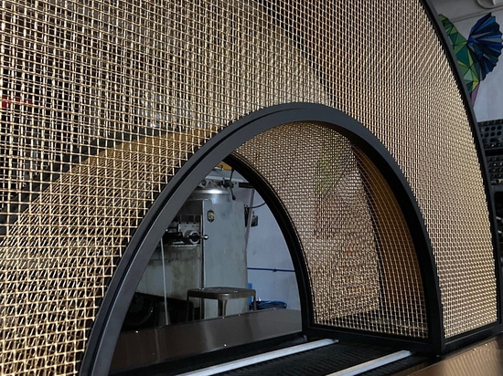Arche courbe en maille de bronze conçue et fabriquée par Desposito Designs pour le bar Ace Porter de l'Omni San Diego