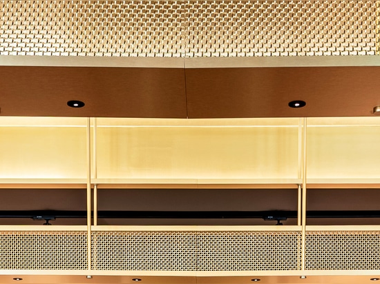 Un espace de dégustation de vin contemporain est doté d'un portique de plafond en treillis métallique en laiton M22-83 qui forme une voûte sculpturale au-dessus du bar.