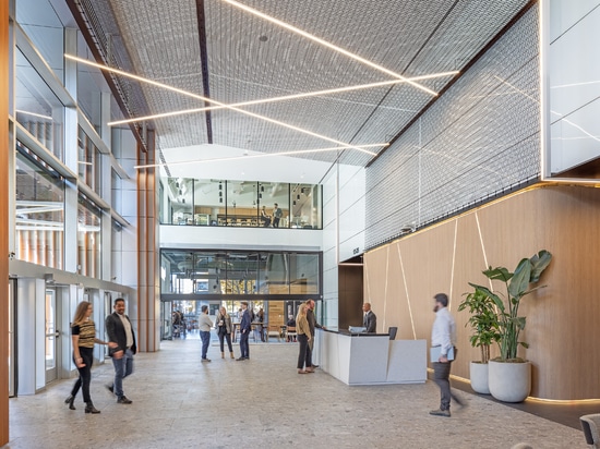 Le treillis métallique souple Dune 40100 prolonge le motif texturé de la façade extérieure jusqu’à l’espace accueillant du hall d’entrée.